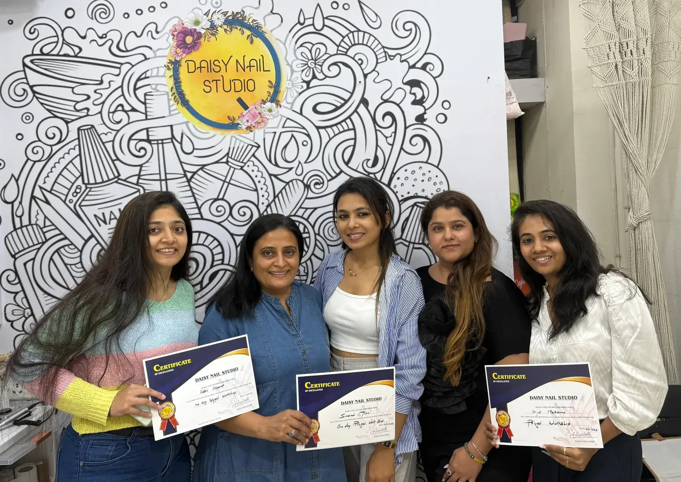 A graduating Daisy Nail Academy batch holding their Certificates of Excellence