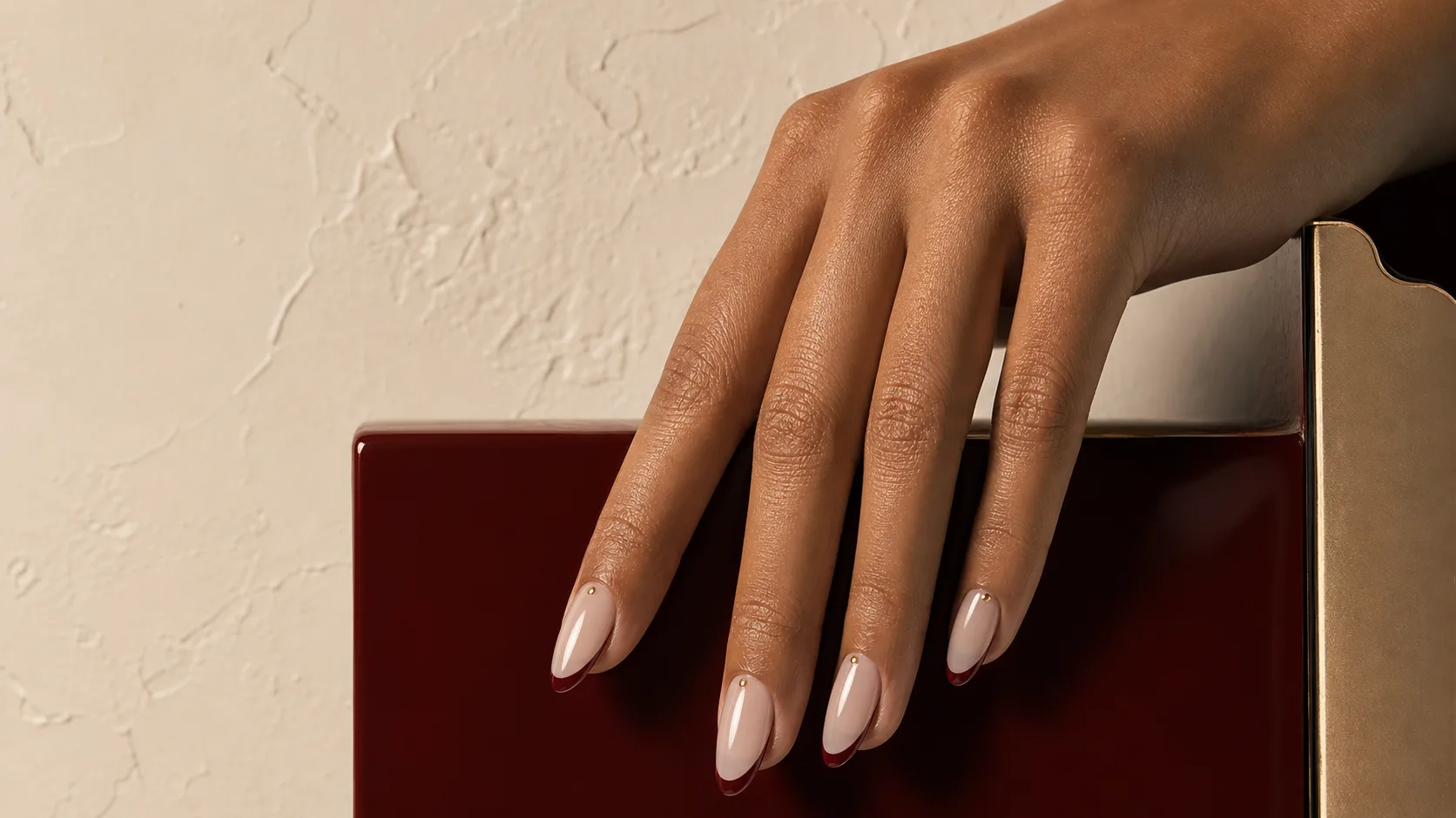 Milky nude nail extensions with oxblood French tips