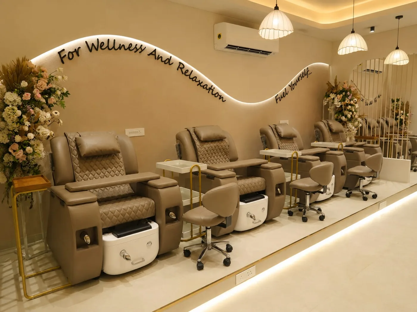 A row of quilted-leather pedicure chairs inside a Daisy studio