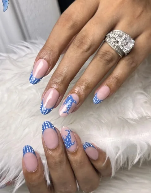An almond manicure finished with blue polka-dot French tips