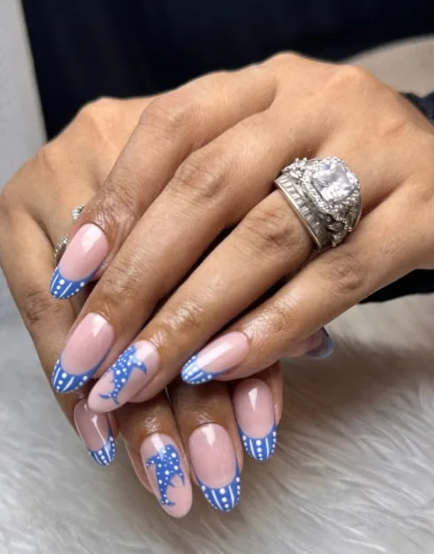 Sheer pink nails with blue polka-dot French tips and hand-painted whale motifs
